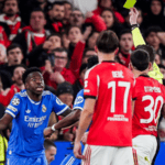 Real Madrid secured a narrow but valuable 1-0 advantage in the first leg of their UEFA Champions League knockout playoff against Benfica at the Estádio da Luz on February 17, 2026. The decisive moment came from Vinícius Júnior, whose brilliant second-half strike proved the difference. However, the Brazilian forward’s goal was quickly overshadowed by a serious claim of racist abuse directed at him, prompting the referee to pause the match for approximately 10–11 minutes while FIFA’s anti-racism protocol was activated