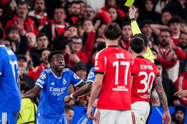 Real Madrid secured a narrow but valuable 1-0 advantage in the first leg of their UEFA Champions League knockout playoff against Benfica at the Estádio da Luz on February 17, 2026. The decisive moment came from Vinícius Júnior, whose brilliant second-half strike proved the difference. However, the Brazilian forward’s goal was quickly overshadowed by a serious claim of racist abuse directed at him, prompting the referee to pause the match for approximately 10–11 minutes while FIFA’s anti-racism protocol was activated